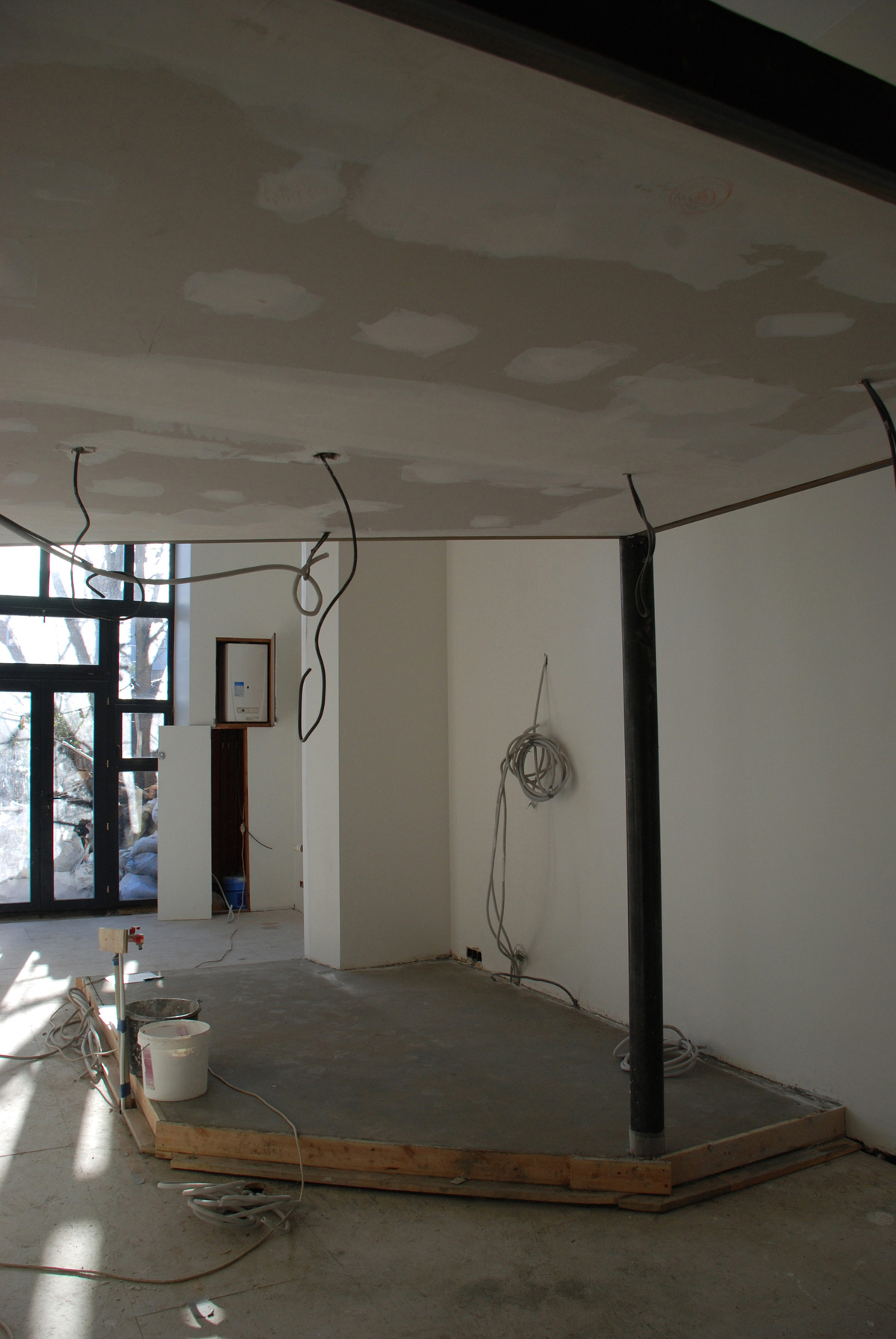 en cours de chantier : en dessous de la mezzanine, vue vers la cuisine et le béton de sol en cours de séchage
